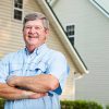 Senior man (60s) standing in back yard.